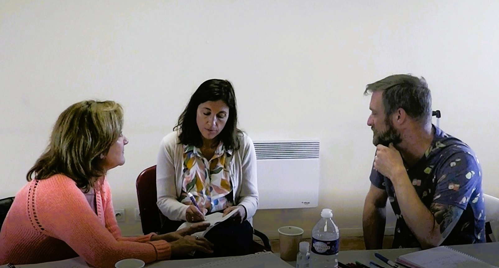 groupe de trois assis, discussion en salle